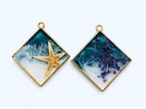 Resin pendants featuring a starfish and purple flowers, handcrafted jewellery by Encore Creations.
